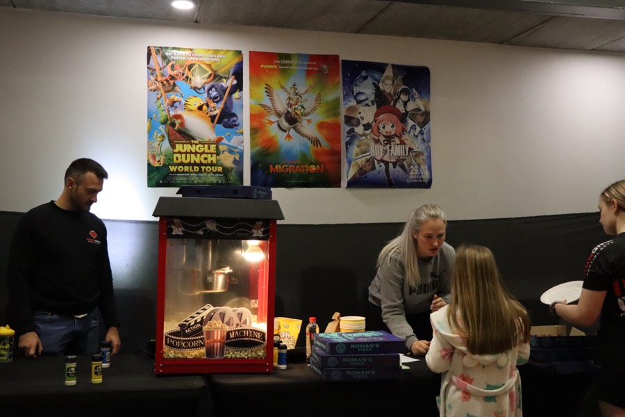 The popcorn station with a popcorn machine and movie posters on the wall